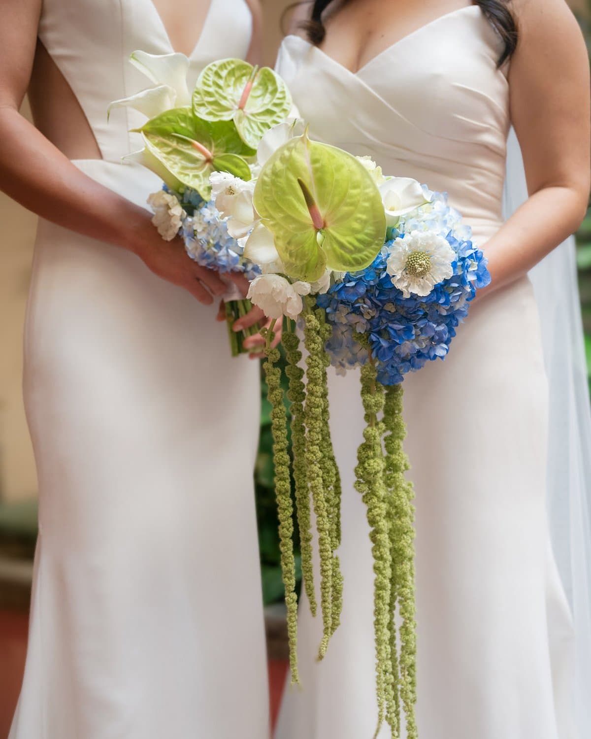 Bridal bouquet with blue hydrangea, green anthurium, scabiosa, and trailing green amaranthus
